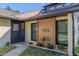 Charming home entrance with decorative wood facade, landscaped garden bed, and inviting front door at 210 Sage Brush Trl, Ormond Beach, FL 32174