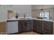 Kitchen featuring a breakfast bar, wood cabinets with gold pulls, and stainless dishwasher at 210 Sage Brush Trl, Ormond Beach, FL 32174