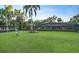 A large, green lawn leads to a house with a screened-in pool area, promising a private outdoor space at 2149 Hontoon Rd, Deland, FL 32720