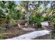Relaxing backyard with gravel, stone pathway, Adirondack chairs, and lush greenery at 2149 Hontoon Rd, Deland, FL 32720
