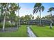 Lush backyard showcasing a stone pathway connecting two dwellings, surrounded by mature trees and landscaping at 2149 Hontoon Rd, Deland, FL 32720
