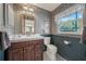 Bathroom showcasing a vanity with wood cabinetry, toilet, and a window overlooking an outdoor view at 2149 Hontoon Rd, Deland, FL 32720