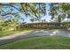 Well-manicured front lawn featuring landscaping, decorative fountain, and paved driveway at 2149 Hontoon Rd, Deland, FL 32720