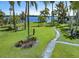 Beautifully landscaped front yard with a stone pathway leading to the waterfront, accented by palm trees at 2149 Hontoon Rd, Deland, FL 32720