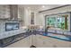 Close-up of a bright kitchen featuring stainless steel appliances, custom tile backsplash, and a view of the outdoors at 2149 Hontoon Rd, Deland, FL 32720