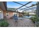 An inviting covered patio features a tiled floor and comfortable seating near a screened pool at 2149 Hontoon Rd, Deland, FL 32720