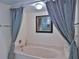 Close up view of soaking tub with decorative surround and matching curtain at 2200 N Atlantic Ave # 1201, Daytona Beach, FL 32118