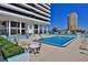 Exterior shot featuring a community pool, lounge furniture and building at 2200 N Atlantic Ave # 1201, Daytona Beach, FL 32118