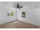 Bright bedroom with modern ceiling fan, wood-look flooring, and natural light from two windows at 2240 Conway Dr, Deltona, FL 32738