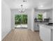 Eat in kitchen with white cabinets, hardwood floors, stainless steel appliances and access to backyard at 2240 Conway Dr, Deltona, FL 32738