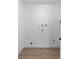 Empty white laundry room with laminate flooring and wall-mounted water and drain pipes at 2240 Conway Dr, Deltona, FL 32738