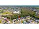 An aerial view displays the property near a school, lake and green space at 2274 Stonehedge Loop, Kissimmee, FL 34743