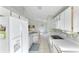 Galley kitchen with white cabinets, appliances, and tile flooring at 2274 Stonehedge Loop, Kissimmee, FL 34743