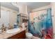 Charming bathroom with decorative turtle shower curtain, granite countertops, and ample storage at 2301 Angel Fish Loop, Leesburg, FL 34748
