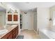Bathroom featuring dual sinks, soaking tub, tiled floors, and a walk-in shower at 2301 Angel Fish Loop, Leesburg, FL 34748