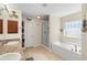 Bathroom featuring a dual vanity, soaking tub, and a separate glass-enclosed shower at 2301 Angel Fish Loop, Leesburg, FL 34748