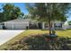 Charming single-story home with a well-maintained lawn, colorful flowerbeds, and a two-car garage at 2301 Angel Fish Loop, Leesburg, FL 34748
