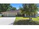 Inviting single-story home with manicured lawn, colorful flowers, and convenient two-car garage at 2301 Angel Fish Loop, Leesburg, FL 34748