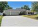 Charming single-story home featuring a well-manicured lawn and a two car garage at 2301 Angel Fish Loop, Leesburg, FL 34748