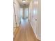 Hallway featuring hardwood floors, leading to bedrooms and bathrooms with matching white doors and trim at 2301 Angel Fish Loop, Leesburg, FL 34748