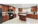 Spacious kitchen with granite countertops, island, tile floors, and dark wood cabinetry at 2301 Angel Fish Loop, Leesburg, FL 34748