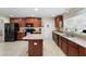 Spacious kitchen with granite countertops, island, tile floors, and dark wood cabinetry at 2301 Angel Fish Loop, Leesburg, FL 34748