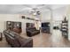 Spacious living room with vaulted ceilings, ceiling fan, wood floors, and comfortable leather seating at 2301 Angel Fish Loop, Leesburg, FL 34748