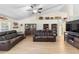 Open living space with leather sofas, ceiling fan, modern flooring, and vaulted ceiling at 2301 Angel Fish Loop, Leesburg, FL 34748
