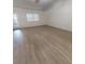 Bright living room featuring hardwood floors, access to patio, and large window for natural light at 2301 Angel Fish Loop, Leesburg, FL 34748