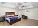 Serene primary bedroom featuring wood floors, tray ceiling, and an inviting seating area at 2301 Angel Fish Loop, Leesburg, FL 34748