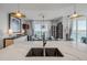 Stylish kitchen island featuring a sink and marble countertops, with dining area and waterfront views at 241 Riverside Dr # 601, Daytona Beach, FL 32117