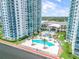 Lovely pool area nestled between high-rise condo buildings, featuring a large pool and lush landscaping at 241 Riverside Dr # 601, Daytona Beach, FL 32117
