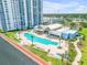 Beautiful waterfront pool area featuring lounge chairs, a jacuzzi, palm trees, and a clubhouse at 241 Riverside Dr # 601, Daytona Beach, FL 32117