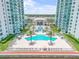 Stunning pool area between condo buildings featuring a large pool, lounge seating, and lush landscaping at 241 Riverside Dr # 601, Daytona Beach, FL 32117