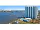 An aerial view of the condo building on the water featuring a pool, a dock, and picturesque bridges at 241 Riverside Dr # 704, Holly Hill, FL 32117
