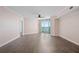 The empty living room is spacious with wood-look floors and sliding glass doors opening to a balcony at 241 Riverside Dr # 704, Holly Hill, FL 32117