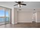 The large empty living room has water views from the sliding glass doors to the balcony and wood-look floors at 241 Riverside Dr # 704, Holly Hill, FL 32117