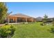 Spacious backyard with a covered patio, lush lawn, and mature landscaping at 2454 Hyatt Creek Ln, Port Orange, FL 32128