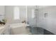 Bright bathroom features a glass enclosed shower, soaking tub and tiled floors and walls at 2454 Hyatt Creek Ln, Port Orange, FL 32128