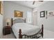Bedroom features a wooden and metal bed frame, bedside table, and a picturesque wall painting at 2454 Hyatt Creek Ln, Port Orange, FL 32128
