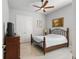 Bedroom features a wood bed frame, ceiling fan, dresser and closet with double doors at 2454 Hyatt Creek Ln, Port Orange, FL 32128