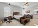 Cozy bedroom has bed, media center, ceiling fan, lounge chair and attached bathroom at 2454 Hyatt Creek Ln, Port Orange, FL 32128