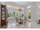 Elegant dining area featuring a glass table, wrought iron chairs, and natural light from the large windows at 2454 Hyatt Creek Ln, Port Orange, FL 32128