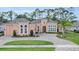 Attractive single-story home featuring a large circular driveway, manicured lawn and a lush tropical landscape at 2454 Hyatt Creek Ln, Port Orange, FL 32128