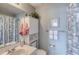 Charming bathroom featuring decor, vanity, mirror, shower and seashell-themed shower curtain at 2480 Ocean Shore Blvd # 120, Ormond Beach, FL 32176
