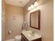 Neat half bathroom featuring a sink, toilet, vanity, mirror, and light fixtures at 2480 Ocean Shore Blvd # 120, Ormond Beach, FL 32176