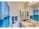 Bright bathroom featuring a well-lit vanity, ample storage, and a stylish shower curtain at 2480 Ocean Shore Blvd # 120, Ormond Beach, FL 32176