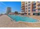 Resort-style pool with clear blue water, surrounding sun loungers, and condominium buildings in the background at 2515 S Atlantic Ave # 509, Daytona Beach, FL 32118