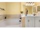 Bright bathroom featuring double sinks, tile flooring, and a bathtub with a view of the exterior at 2530 Leonard Dr, Deltona, FL 32725