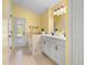 Bright bathroom featuring double sinks, tile flooring, and a bathtub with a view of the exterior at 2530 Leonard Dr, Deltona, FL 32725